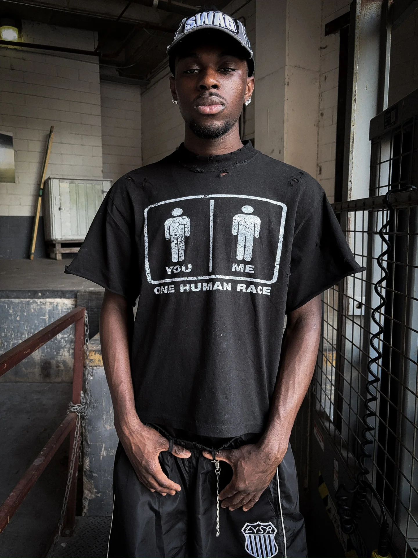 Model in black LVSR Human Race tee and black shorts, front full-body view