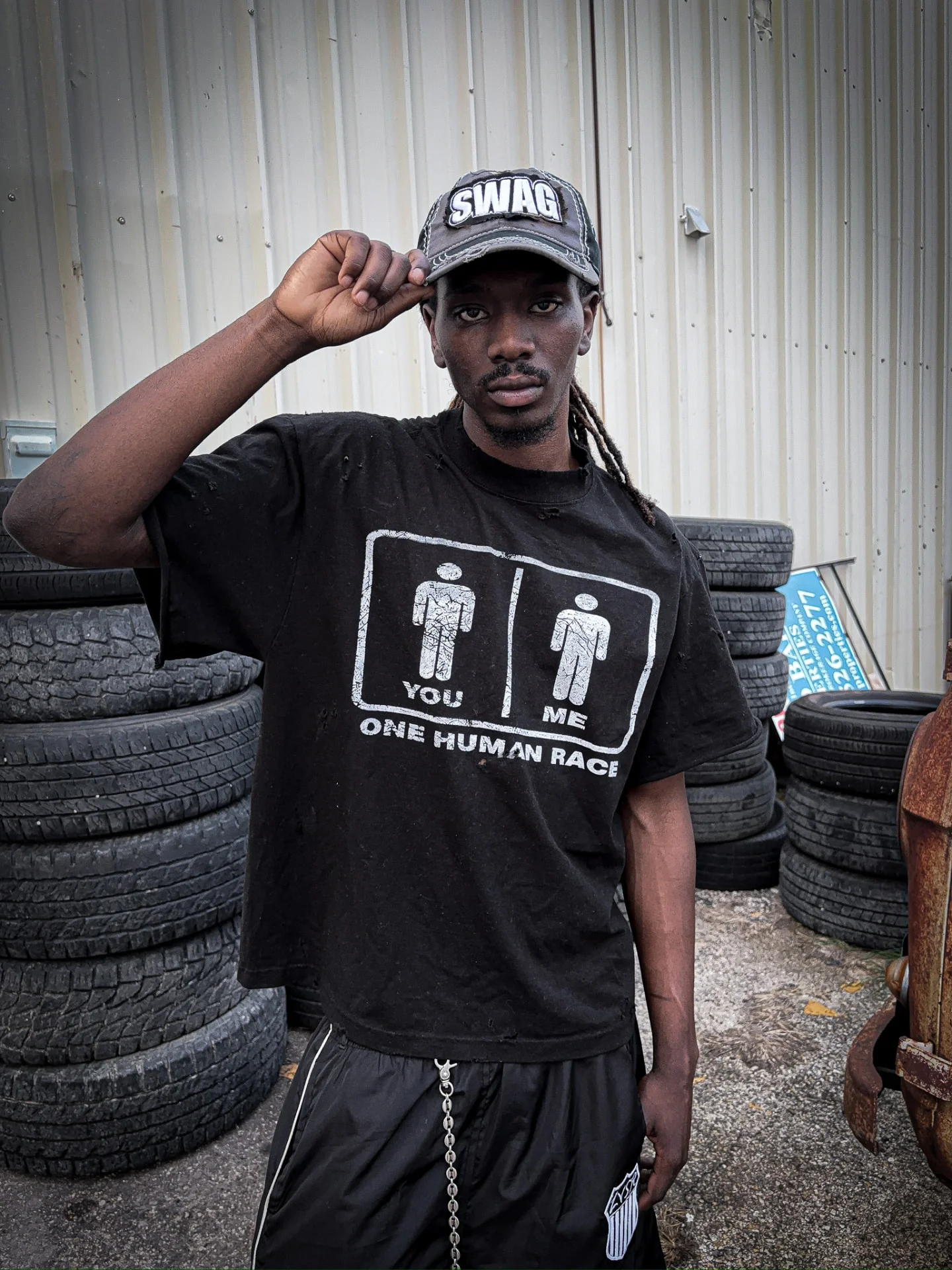 Model in black LVSR Human Race tee and SWAG cap, front view