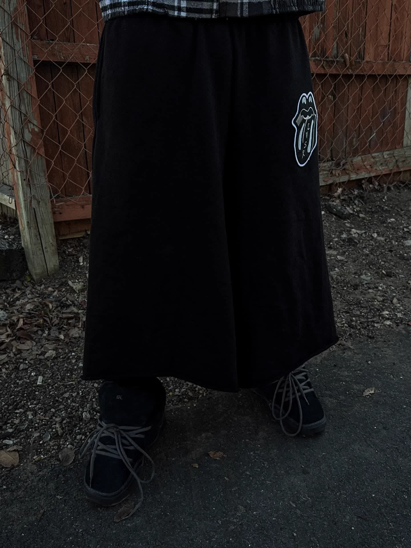 LVSR black wide-leg pants with tongue logo detail, full length front view